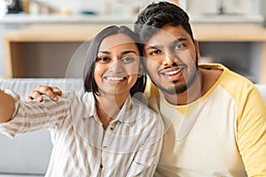 Portrait Of Happy Young Indian Couple Taking Selfie Together At Home