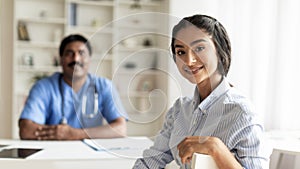 Portrait Of Happy Young Indian Female Patient Sitting At Doctor& x27;s Office