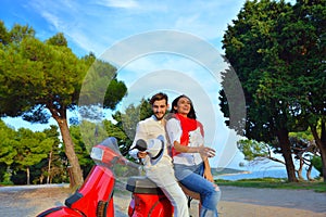 Portrait of happy young love couple on scooter enjoying themselves