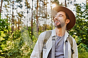 Portrait of happy young man backpacking in forest