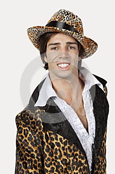 Portrait of happy young man in fur clothing against gray background