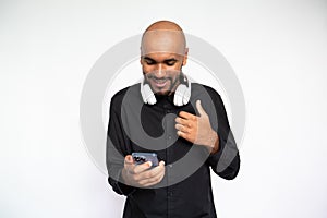 Portrait of happy young man with headphones using smartphone