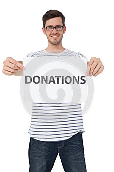 Portrait of a happy young man holding a donation note