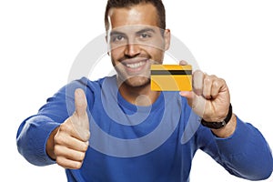 Portrait of happy young man, holding empty credit card and showing thumbs up