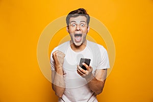 Portrait of a happy young man holding mobile phone