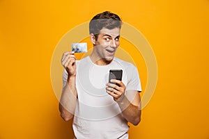 Portrait of a happy young man holding mobile phone