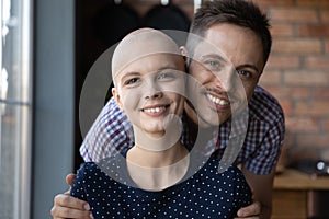 Portrait of happy young man hugging beloved woman with cancer