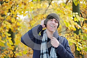 Portrait of a happy young man laughing outdoors with hat