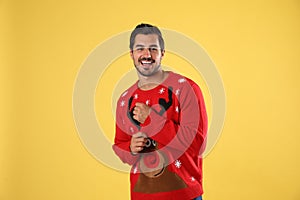 Portrait of happy young man in  sweater on yellow background