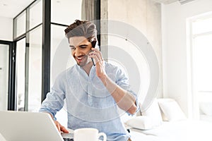 Portrait of a happy young man using laptop computer