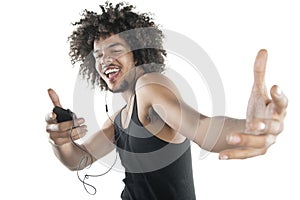 Portrait of a happy young man in vest dancing to tunes of mp3 player over white background