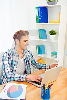 Portrait of happy young man working with laptop and diagrama photo
