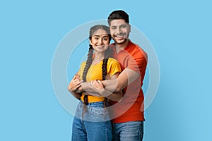Portrait Of Happy Young Middle Eastern Couple Embracing And Smiling At Camera