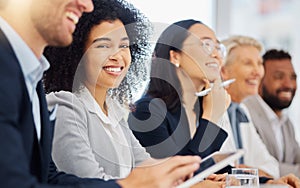 Portrait of happy young mixed race businesswoman listening to presentation during meeting in office boardroom with