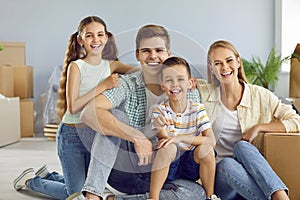 Portrait of happy young modern family with children who are moving into their own new house.