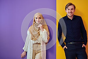 Portrait of happy young muslim couple standing isolated on colorful background