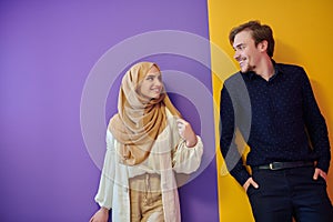 Portrait of happy young muslim couple standing isolated on colorful background