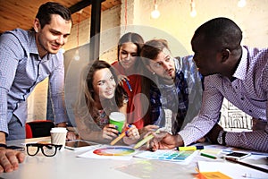 Portrait of happy young people in a meeting looking at camera and smiling. Young designers working together on a