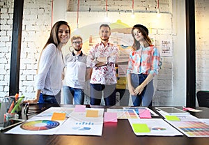 Portrait of happy young people in a meeting looking at camera and smiling. Young designers working together on a