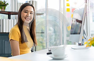 Portrait happy young programmer Asian woman work at start up technology office and using computer for coding application program