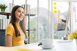 Portrait happy young programmer Asian woman work at start up technology office and using computer for coding application program