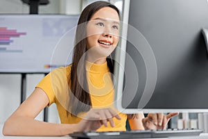 Portrait happy young programmer Asian woman work at start up technology office and using computer for coding application program