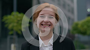 Portrait happy young red haired ginger Caucasian businesswoman female woman slowly turning head laughing looking camera