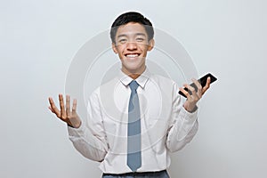 Portrait of happy young student with smiley face holding mobile phone