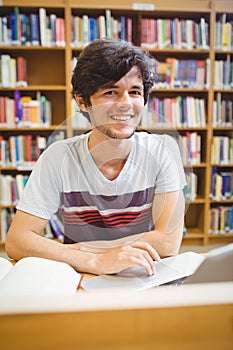 Portrait of happy young student using his laptop