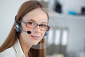 Portrait of happy young support phone operator with headset.