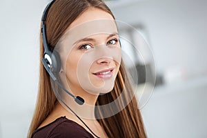 Portrait of happy young support phone operator with headset.