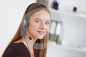 Portrait of happy young support phone operator with headset.