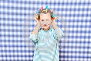 Portrait of happy young woman with colorful hair curlers on head