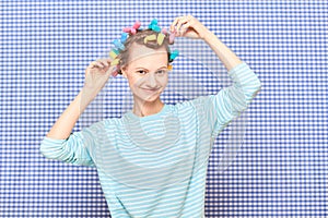 Portrait of happy young woman with colorful hair curlers on head