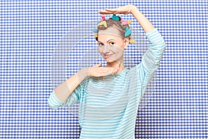 Portrait of happy young woman with colorful hair curlers on head