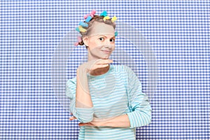 Portrait of happy young woman with colorful hair curlers on head