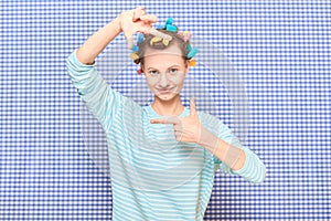 Portrait of happy young woman with colorful hair curlers on head