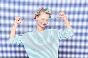 Portrait of happy young woman with colorful hair curlers on head