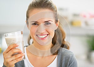 Retrato feliz mujer joven bebiendo en La cocina 