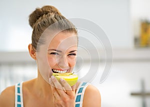 Portrait of happy young woman eating apple
