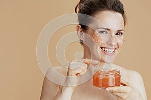 Portrait of happy young woman with face scrub