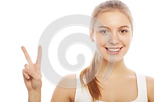 Portrait of happy young woman giving peace sign