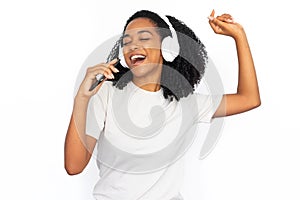 Portrait of happy young woman in headphones singing in phone