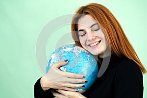 Portrait of a happy young woman holding geographic globe of the world in her hands. Travel destination and planet protection
