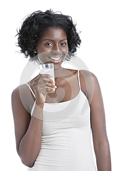 Portrait of happy young woman holding a glass of milk over white background