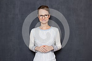 Portrait of happy young woman holding hands folded together