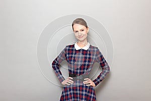 Portrait of happy young woman holding hands on hips and smiling