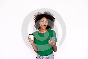 Portrait of happy young woman holding mobile phone and coffee