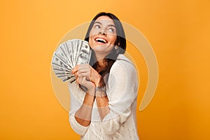 Portrait of a happy young woman holding money banknotes