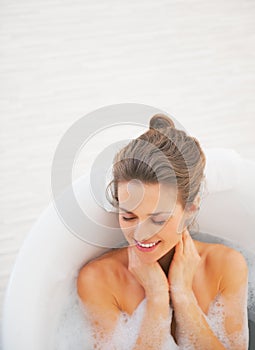 Portrait of happy young woman laying in bathtub